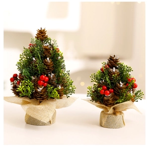 Close-up of mini Christmas trees with red berries, pine cones and burlap base