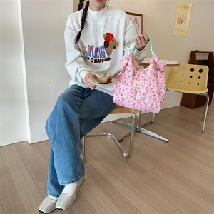 Pink floral canvas tote bag with a cute rabbit embossment held by a casual model