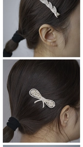 Detail of silver bow and feather hair clips with crystals and pearls worn by a model