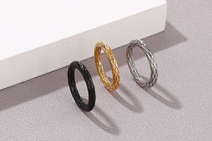 Detail von Titanstahlringen mit Rautenmuster in Gold, Silber und Schwarz poliert