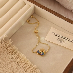 Detail of adjustable gold bracelet with shell inlays and sparkling zircon ring charms
