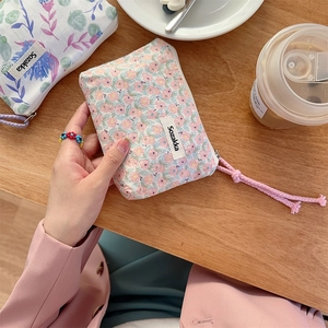 Detailansicht der kleinen Make-up-Tasche aus Segeltuch mit Blumenmuster und Kordel-Reißverschluss