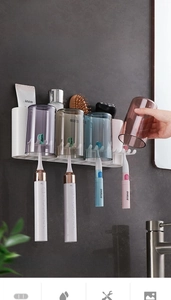 Macro shot of wall-mounted toothbrush holder with four colorful inverted drainage cups