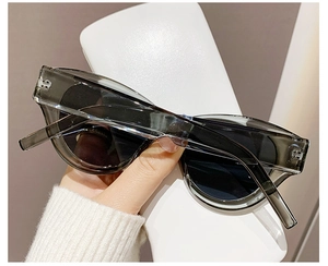 Detail shot of cat eye sunglasses featuring dark grey transparent frames and tinted lenses