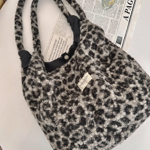 Detail view of leopard print plush tote bag with metal magnetic snap closure and soft texture