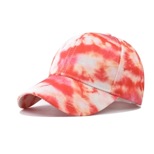 Detailed top view of red and orange tie-dye baseball cap with embroidered eyelets