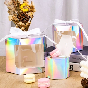 Macro detail of hexagonal laser iridescent gift boxes with windows and white ribbons