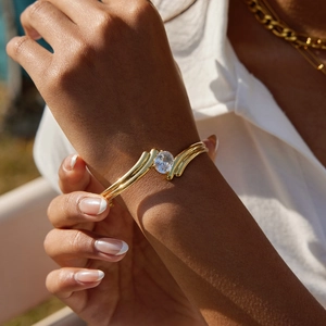 Macro detail of gold-plated titanium steel cuff featuring a large round zircon setting
