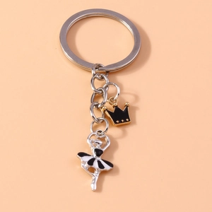 Detailed view of ballet girl charm and crown pendant on a silver metal keychain