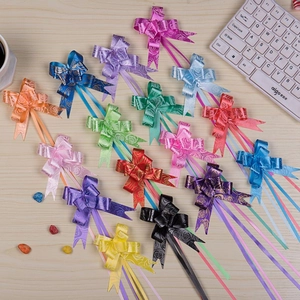 Macro shot of 15 assorted colorful ribbon bows with rose patterns on a light wooden table