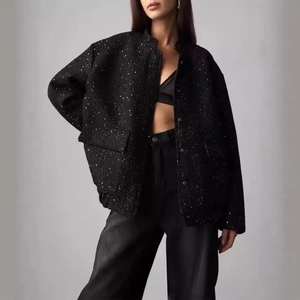 Women's black sequin bomber jacket with high collar shown on model in studio