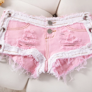 Detalle de shorts vaqueros rosas con ribete blanco, flecos rotos y ojales metálicos