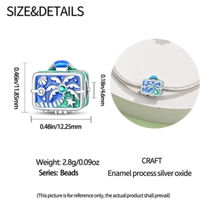 Detailed view of silver suitcase charm with enamel palm tree and green gem for bracelet