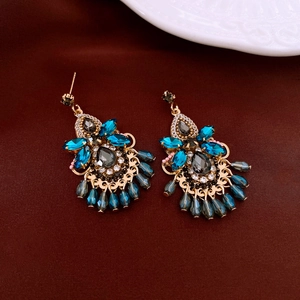 Detailed macro of vintage bohemian earrings with blue crystals and gold metallic base