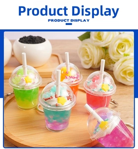 Set of five colorful miniature fake beverage keychains on a wooden display tray