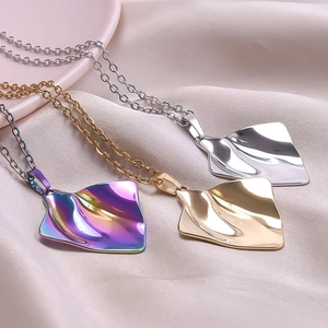 Macro shot of ripple textured gold silver and iridescent stainless steel pendant necklaces