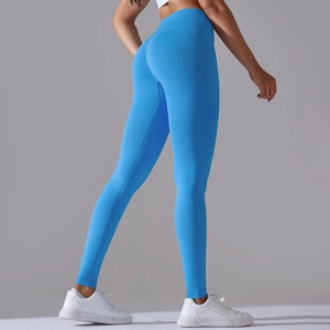 Detail of high-waisted blue seamless yoga pants showing peach lift effect and stretch fabric