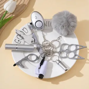 Detail of gray self-defense keychain set with alarm and spray bottle on a white plate