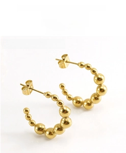Detailed view of 18K gold plated C-shaped earrings featuring a polished beaded design
