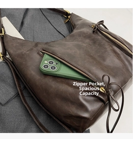 Detail of vintage brown leather tote bag showing exterior zipper pocket for smartphone