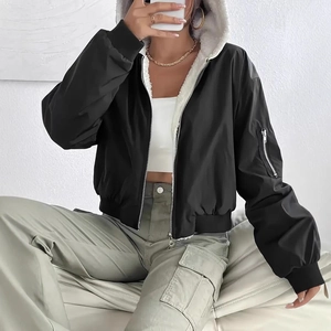Detail of black hooded bomber jacket featuring white faux shearling lining and metal zipper