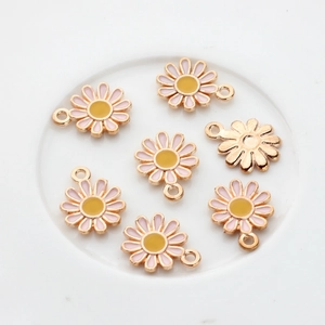 Flat lay of pink enamel daisy flower pendants with gold-plated alloy base for DIY jewelry
