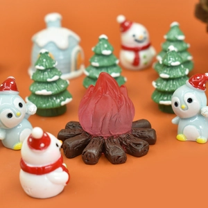 Macro view of Christmas resin miniature campfire with a snowman and penguin scene
