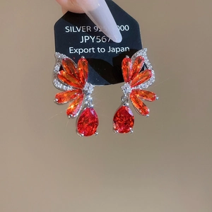 Detail of S925 silver red zircon earrings with delicate teardrop and marquise stones