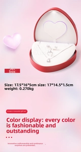 Detail view of heart-shaped LED jewelry box with luxury silver necklace and ring set