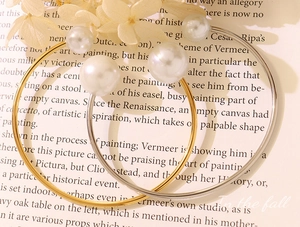Detail of gold and silver open rings with elegant pearls on vintage book pages