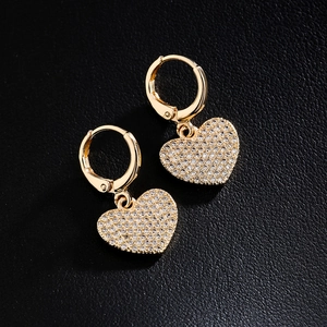 18K gold plated copper earrings with heart-shaped zircon pendants on black leather background