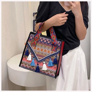 Close-up of bohemian embroidered tote bag with geometric patterns and fringe charms