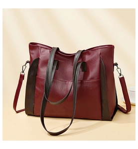 Detail view of burgundy PU leather tote bag with brown straps and fine stitching