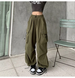 Detail of army green cargo pants showing wide-leg fit and large functional side pockets