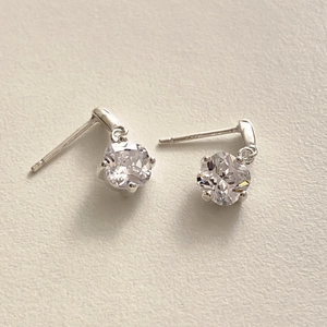 Macro shot of 925 silver stud earrings with white square-cut zircon stone settings