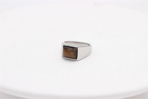 Macro detail of men's silver stainless steel ring with a square brown tiger eye stone