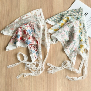 Detail of floral lace hair scarf with daisy patterns and delicate cotton fabric ties