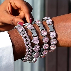 Close-up of pink crystal Cuban link bracelet set with heart and square charms