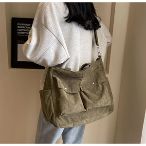 Detailed back view of an army green corduroy tote bag with large front flap pockets
