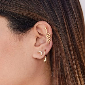 Détail d'un ensemble de bague d'oreille serpent, puce lune et créole éclair dorée