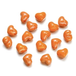 Close-up of 15 orange heart-shaped acrylic beads with a smooth glossy finish for DIY jewelry