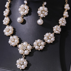 Detailed macro view of bridal jewelry set with golden pearl flower clusters and rhinestones