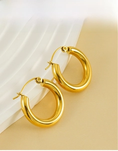 Detailed view of polished 18K gold-plated oval hoop earrings made of titanium steel