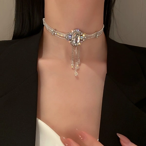 Détail d'un ras du cou argenté avec grand cristal et pendentifs à pampilles étincelants
