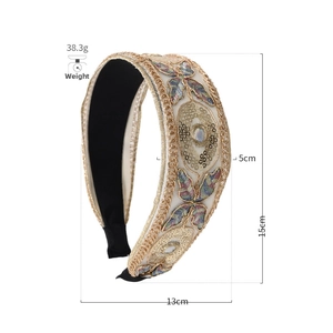Detailed embroidery view of wide lace headband with colorful butterfly and gold sequins