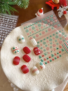Close-up of Christmas nail stickers with 3D embossed snowflake and reindeer designs