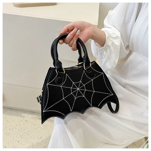 Detailed view of the black bat-shaped handbag with intricate white spider web embroidery