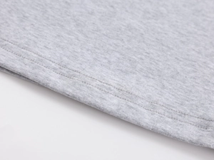 Macro shot of double-needle stitching and knit fabric texture on light grey slim-fit tee