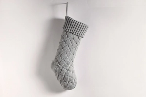 Detailed view of grey knitted Christmas stocking with classic woven pattern texture