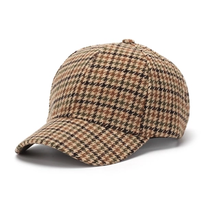 Detail of retro houndstooth baseball cap featuring thick wool fabric and curved brim texture